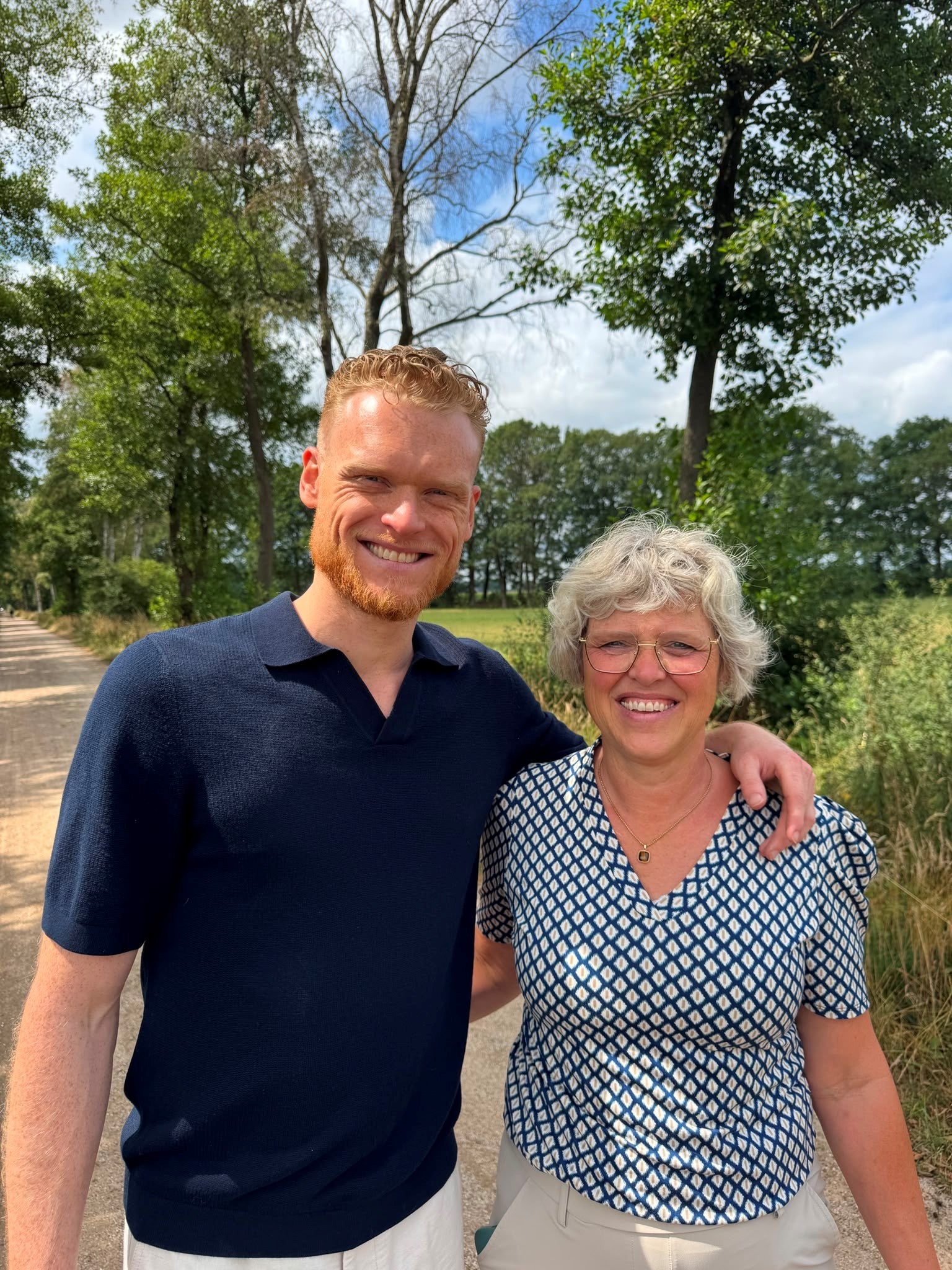 Ray en zijn moeder samen op een zandpad tussen de bomen